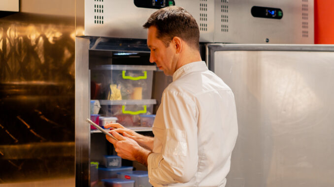 professional kitchen chef looks into the fridge and chooses ingredients for cooking food concept